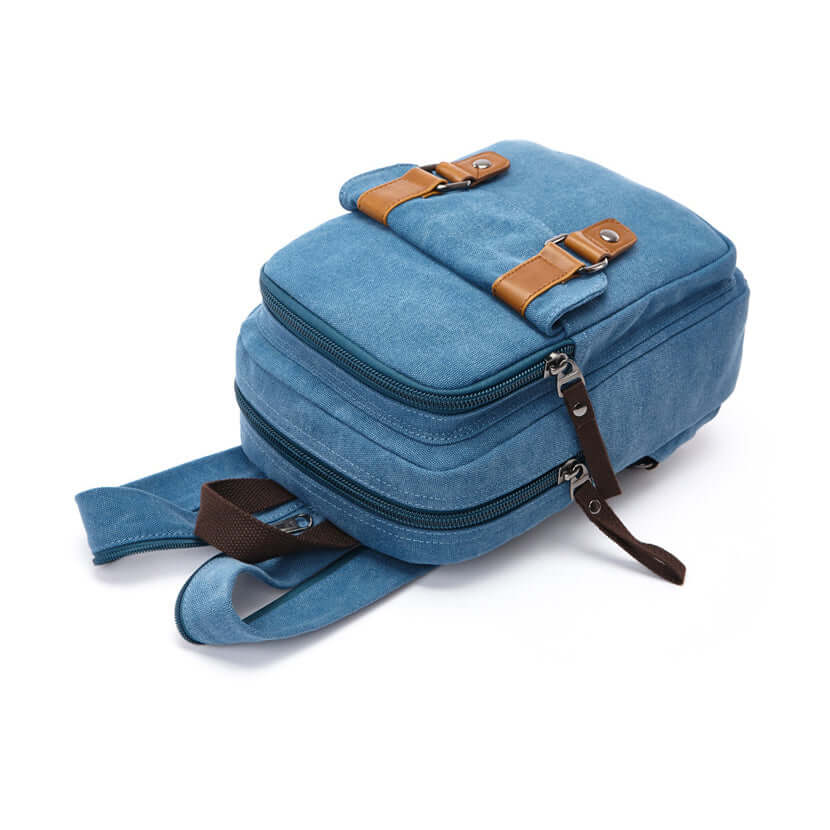 Side view showing dual zip compartments and brown strap