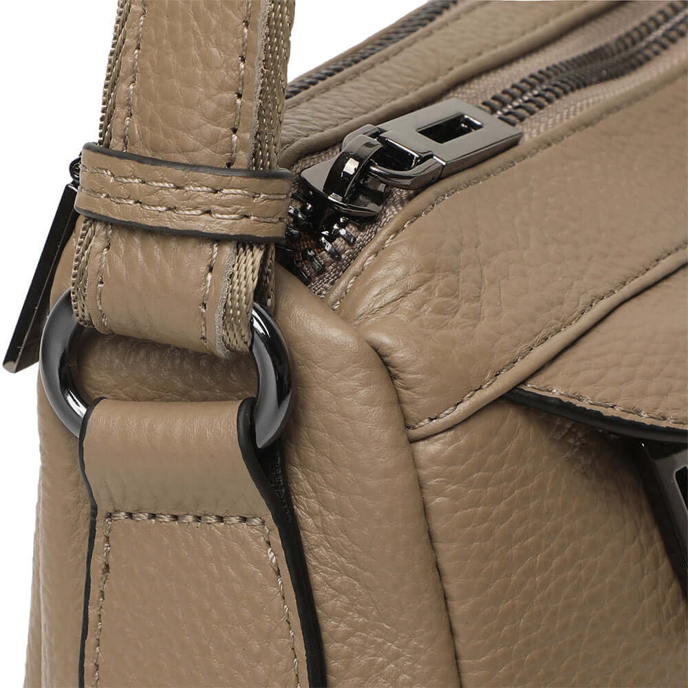 Close-up of a leather bag with zipper and strap details