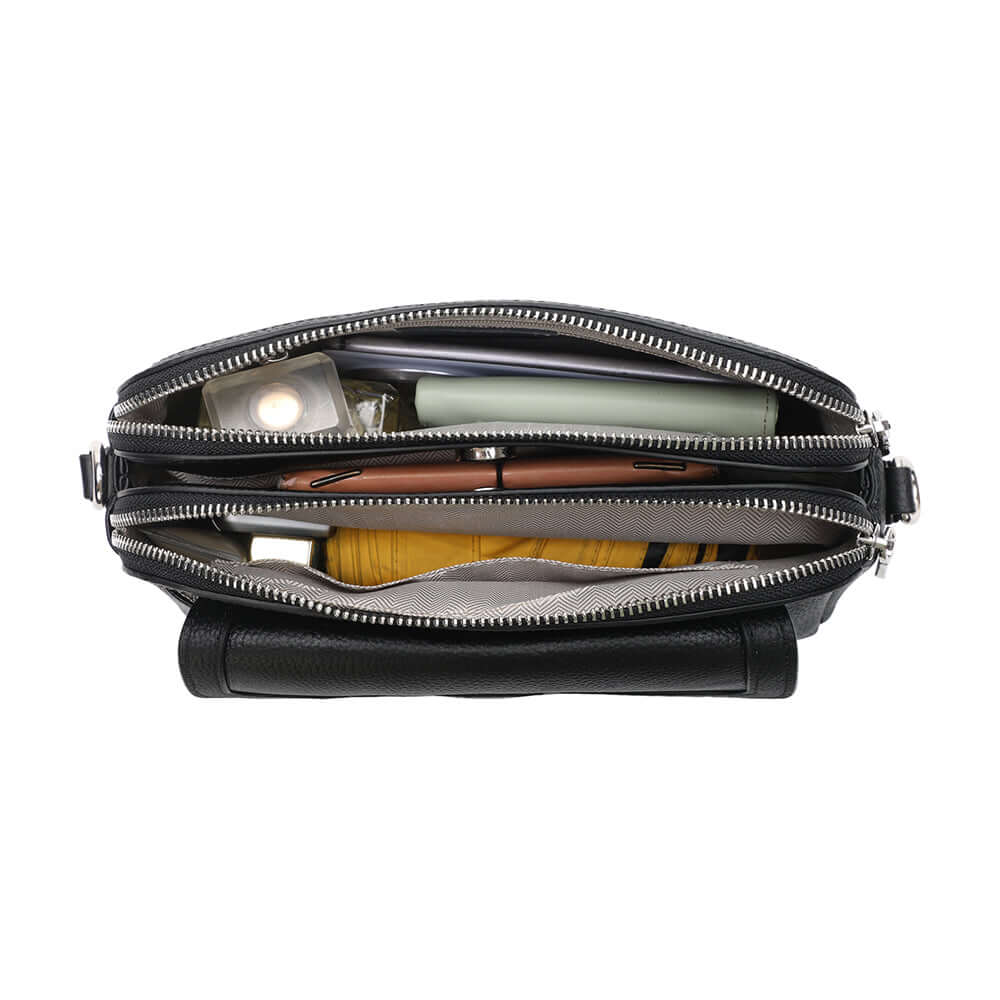 Black leather crossbody bag packed with daily essentials.