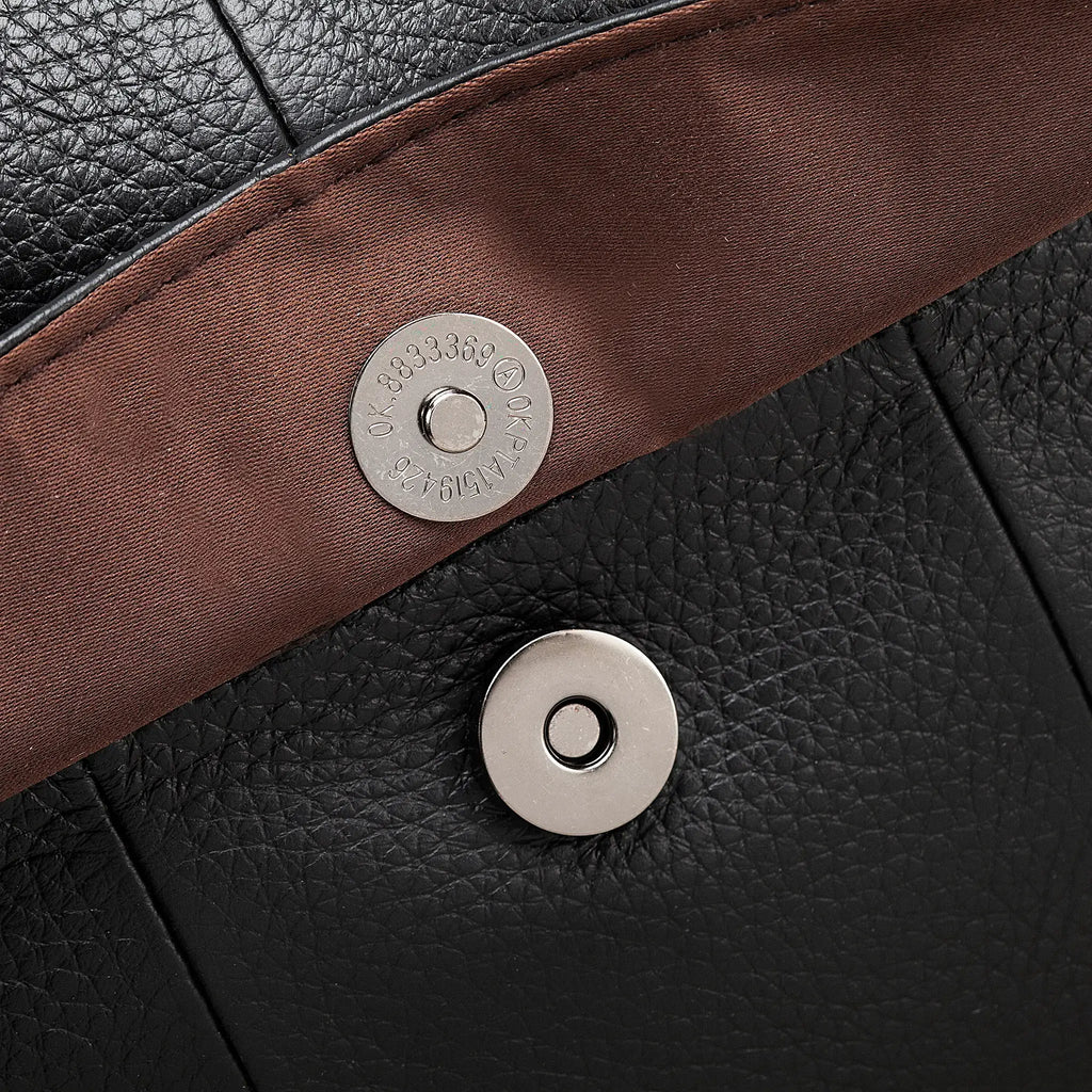 Premium metal hardware and zipper details on black leather bag.