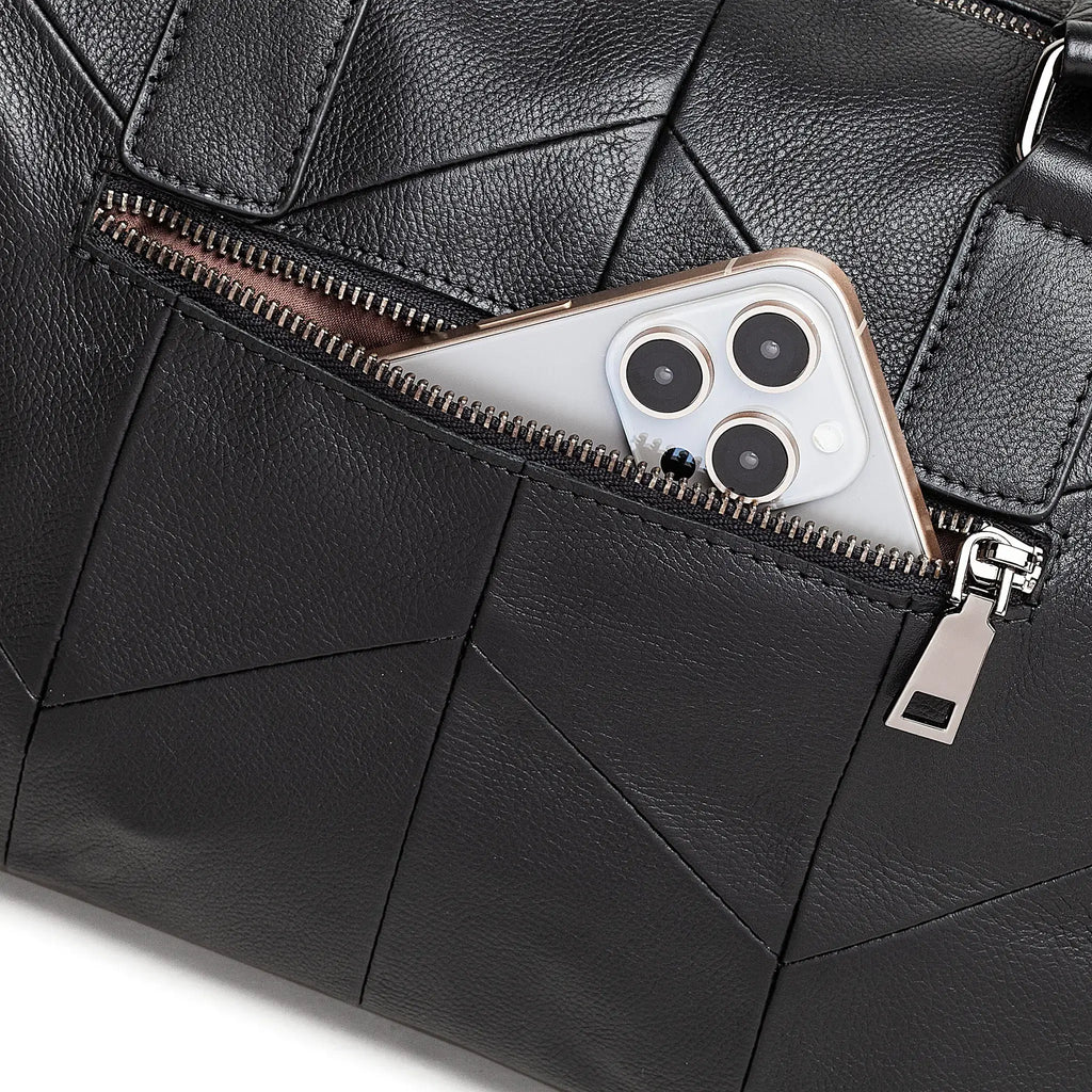 Black leather bag with a zipper pocket containing a smartphone.