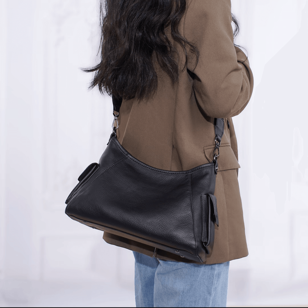 Person carrying a black leather bag.