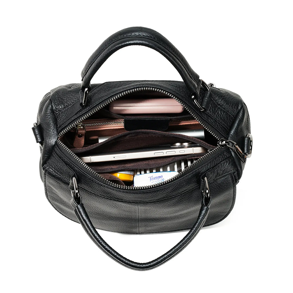 Black leather handbag with compartments and items inside