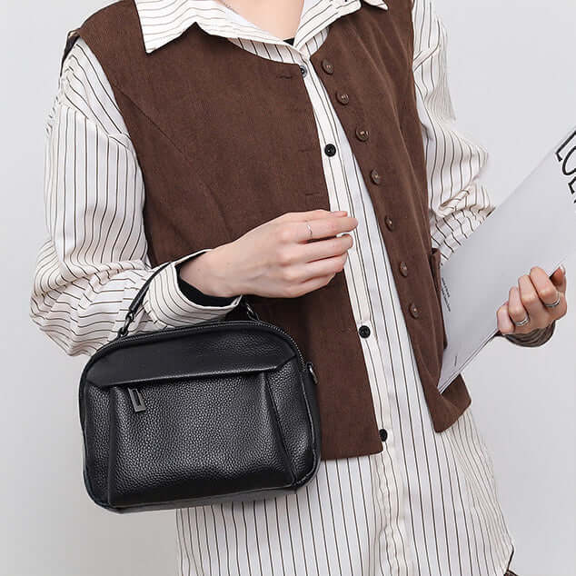 Model holding a black leather bag