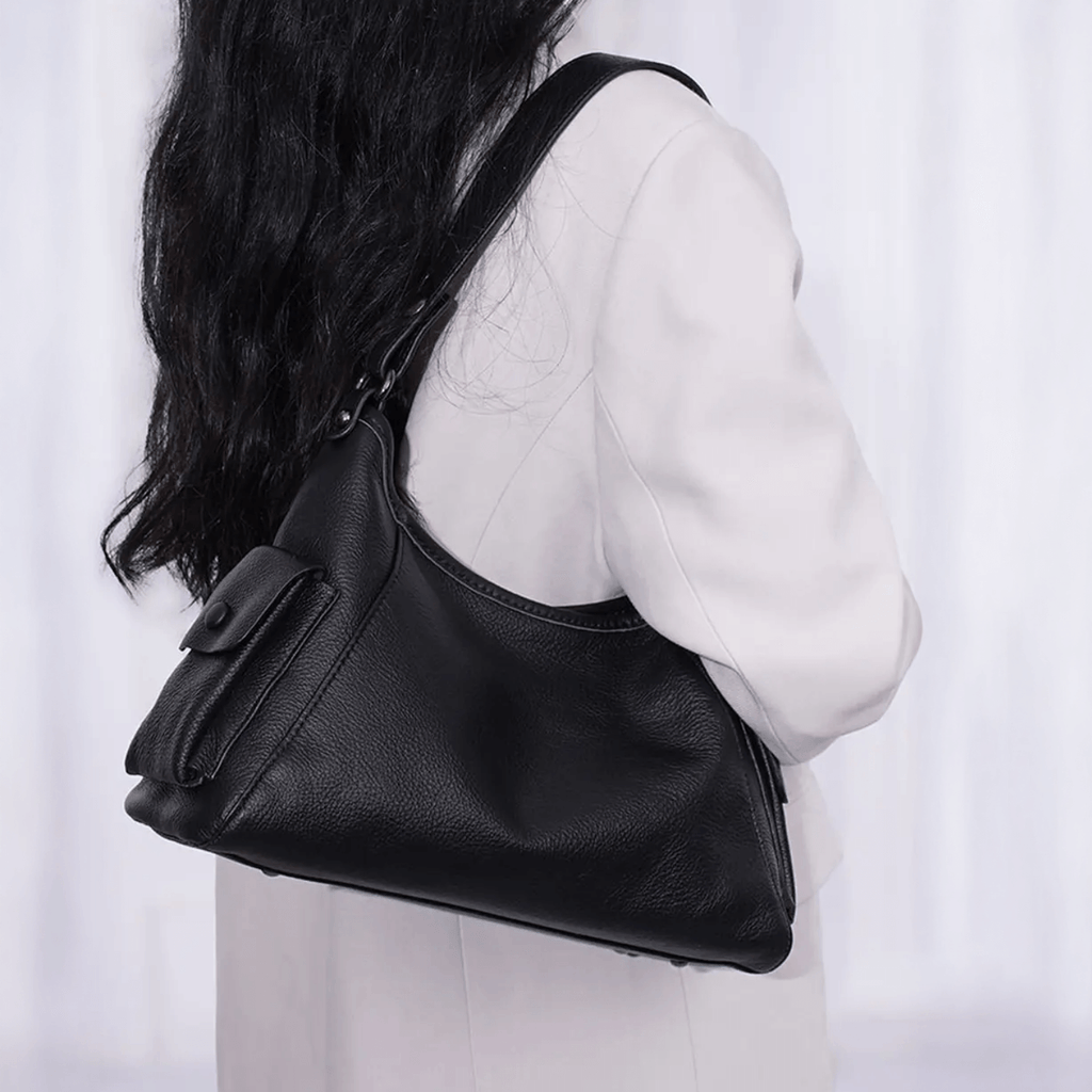 Black leather handbag worn by a person.