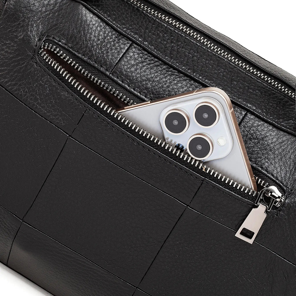 Black leather bag with a zipper pocket containing a smartphone.