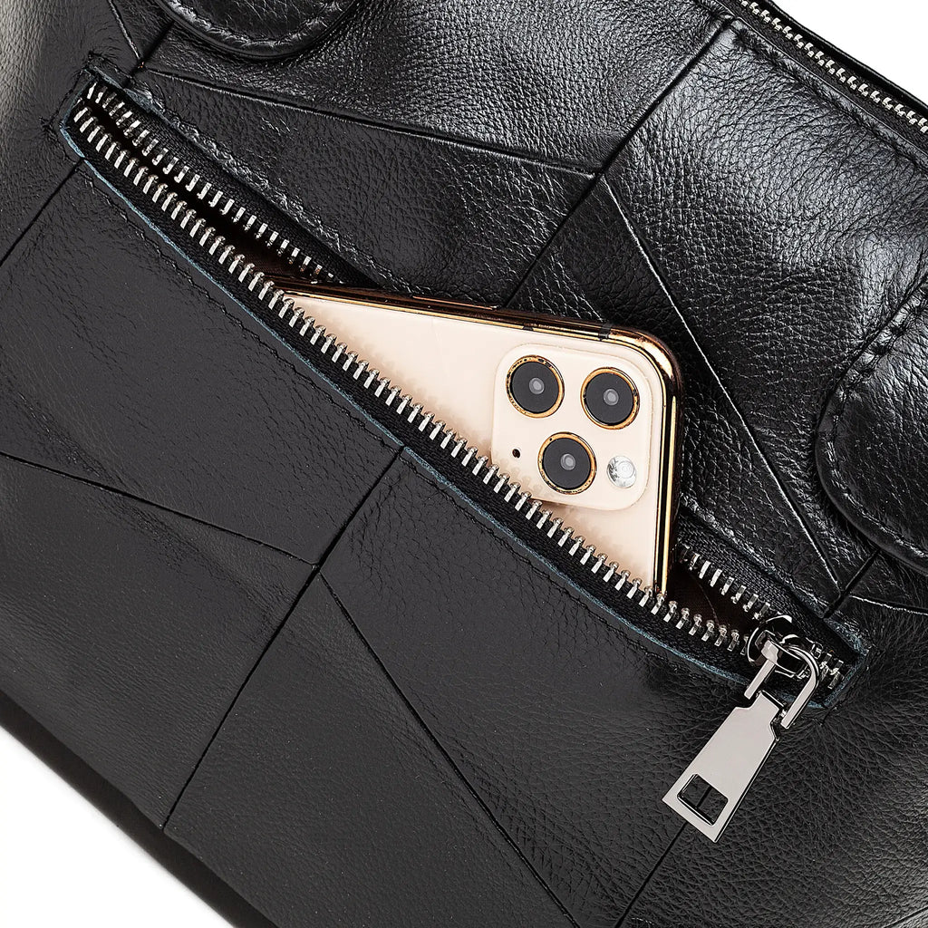 Black leather bag with a gold phone inside a zipper pocket