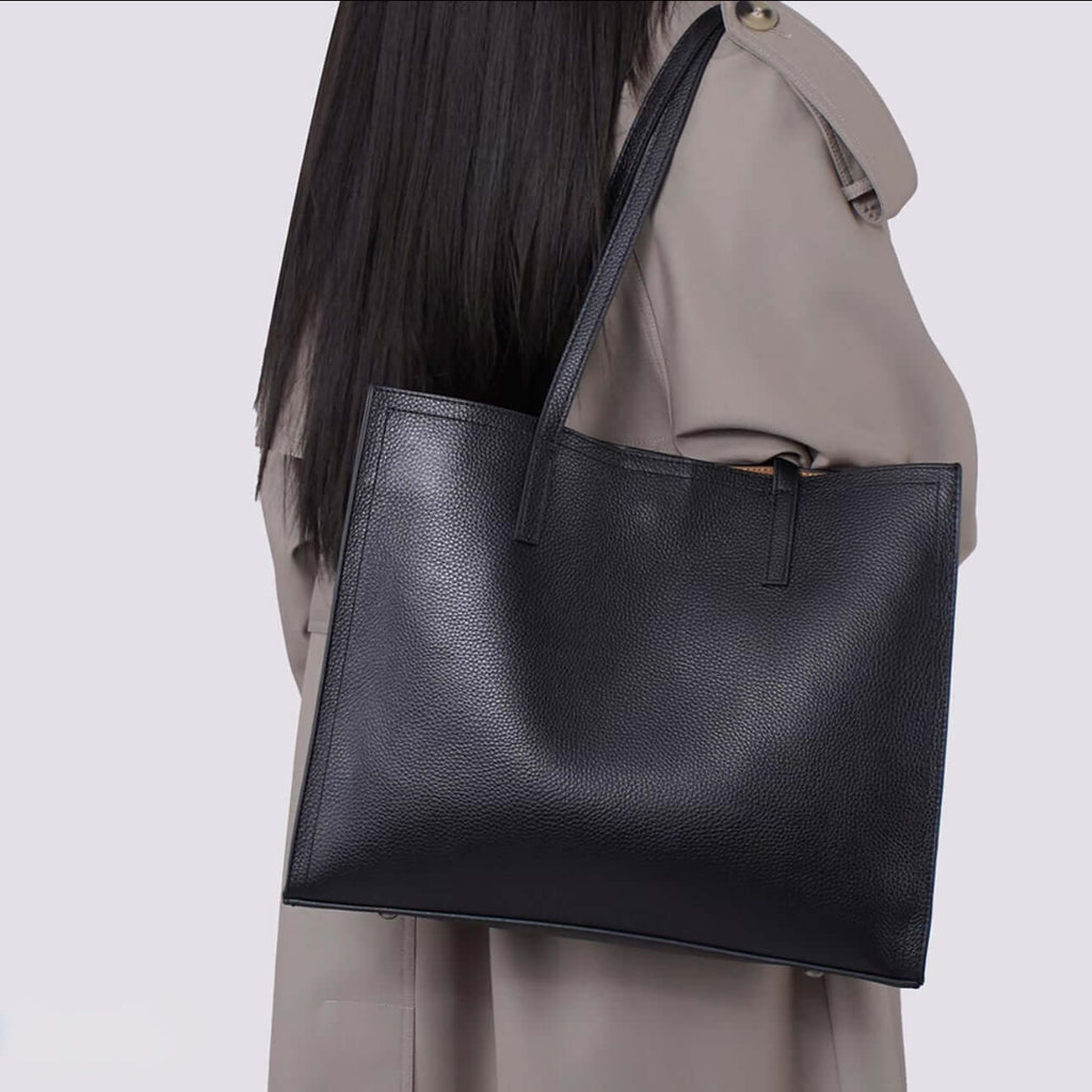 Person wearing a black leather tote bag