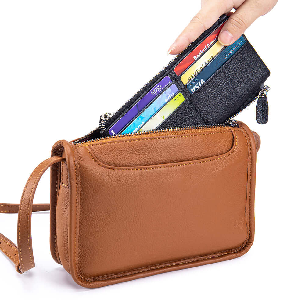 Brown leather crossbody bag with a black cardholder containing colorful cards