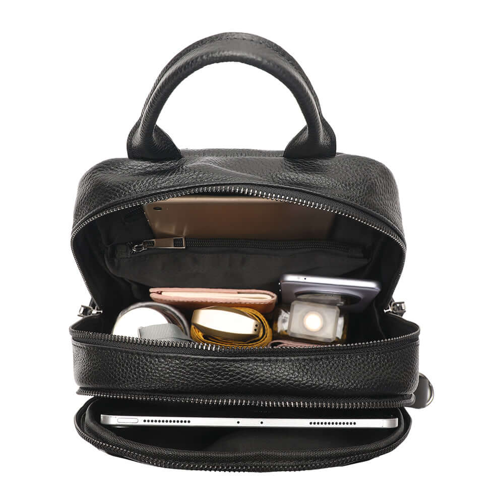 Black leather backpack with compartments containing electronic devices