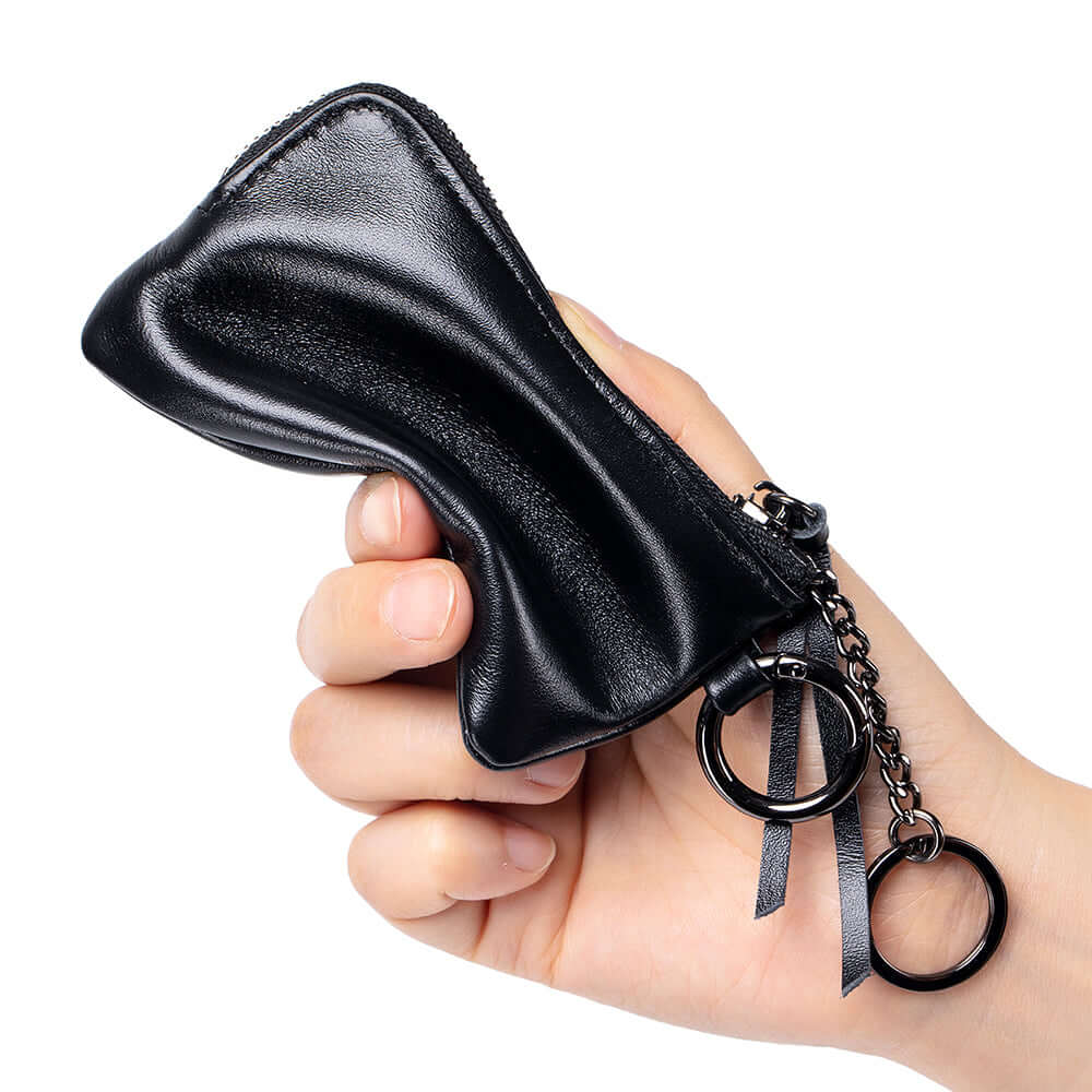 Hand holding a black leather wallet with keychains.