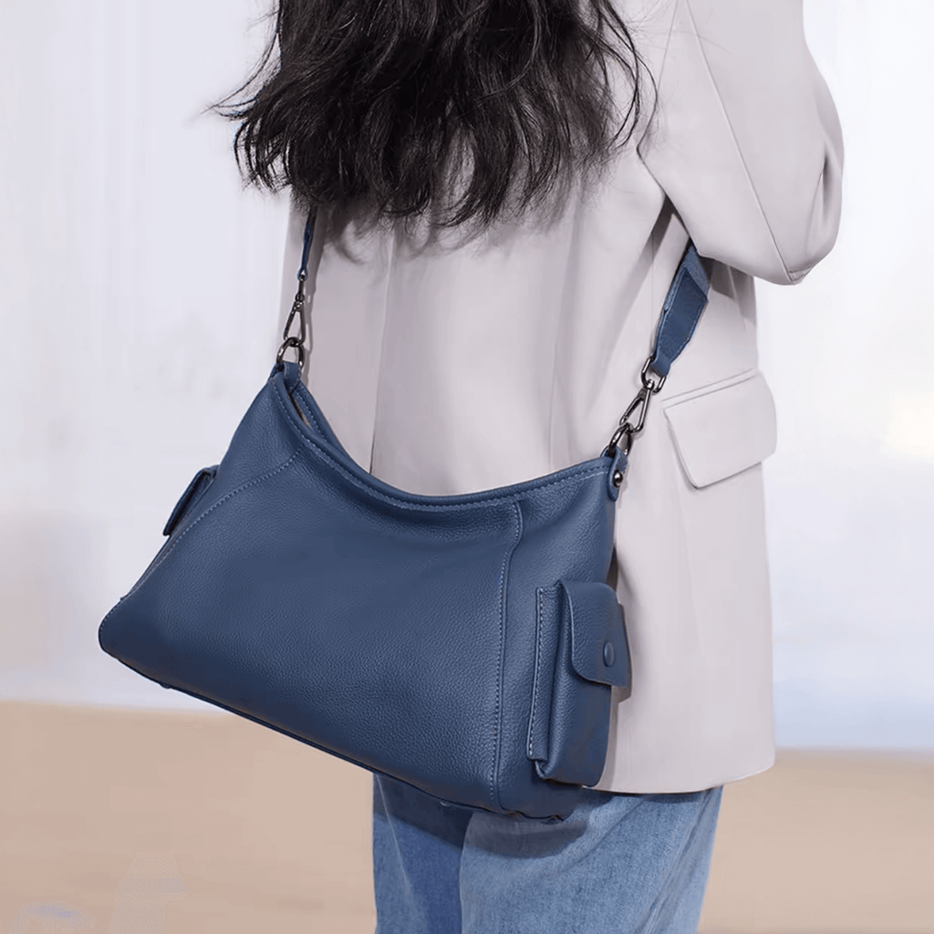 Model displaying blue genuine leather handbag.