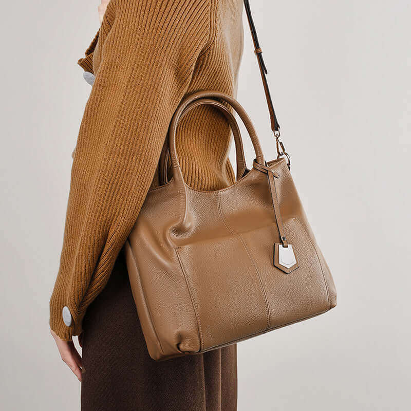 Versatile design of brown leather handbag for multiple carrying styles.