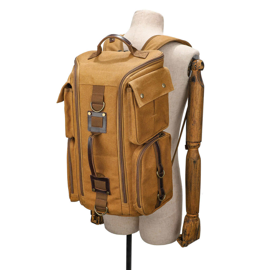 Brown canvas backpack featuring multiple pockets for storage.