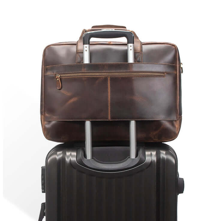 Brown leather briefcase on top of a black suitcase