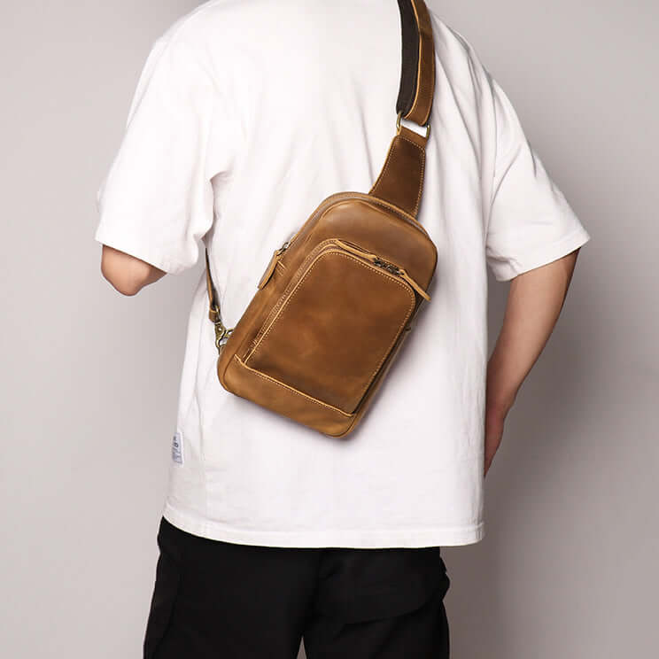 Leather sling bag worn over one shoulder
