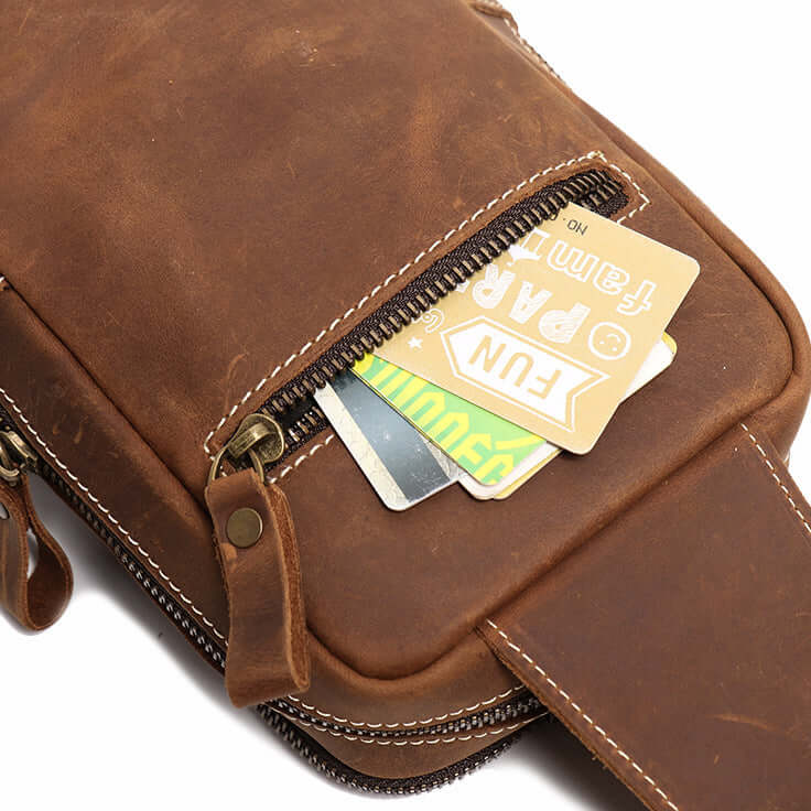 Brown leather sling bag with a card inside