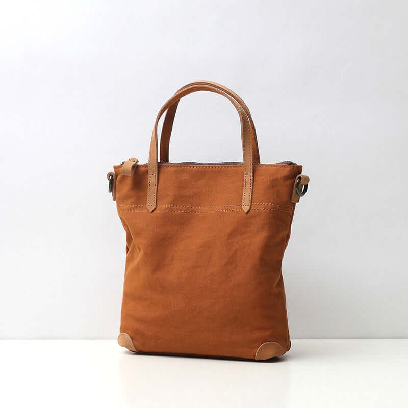 Brown canvas handbag with genuine leather handles.