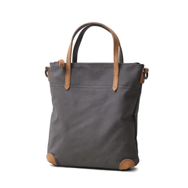 Grey canvas handbag with tan leather trim.