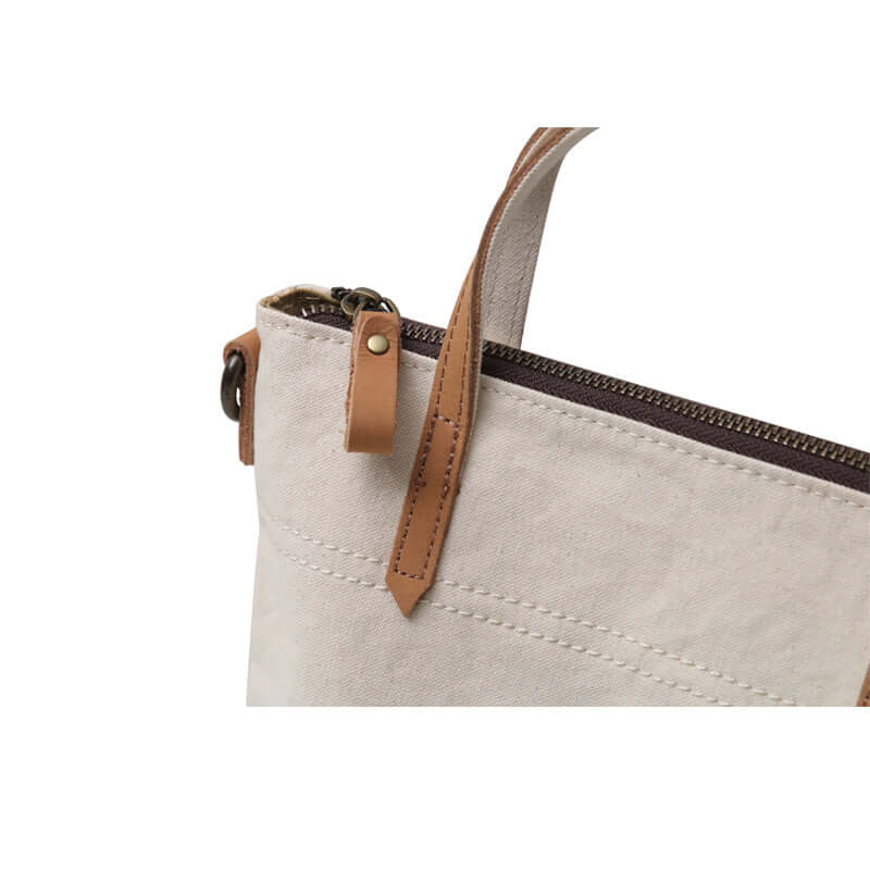Top zipper closure of canvas tote handbag.