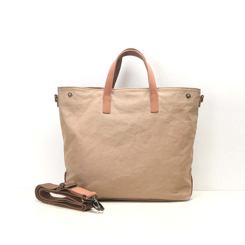 Khaki canvas tote bag with leather trim and handles.