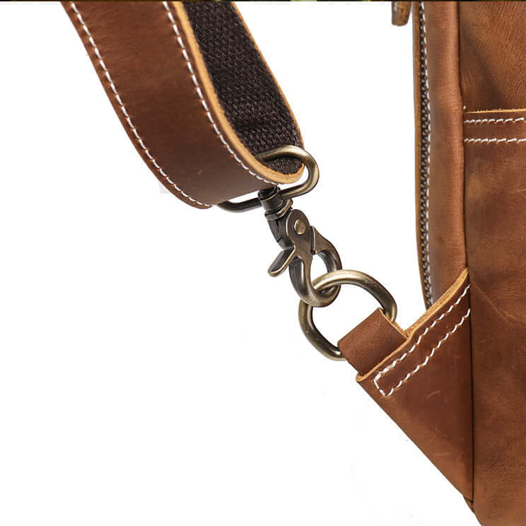 Close-up of a brown leather bag with a strap and metal clasp