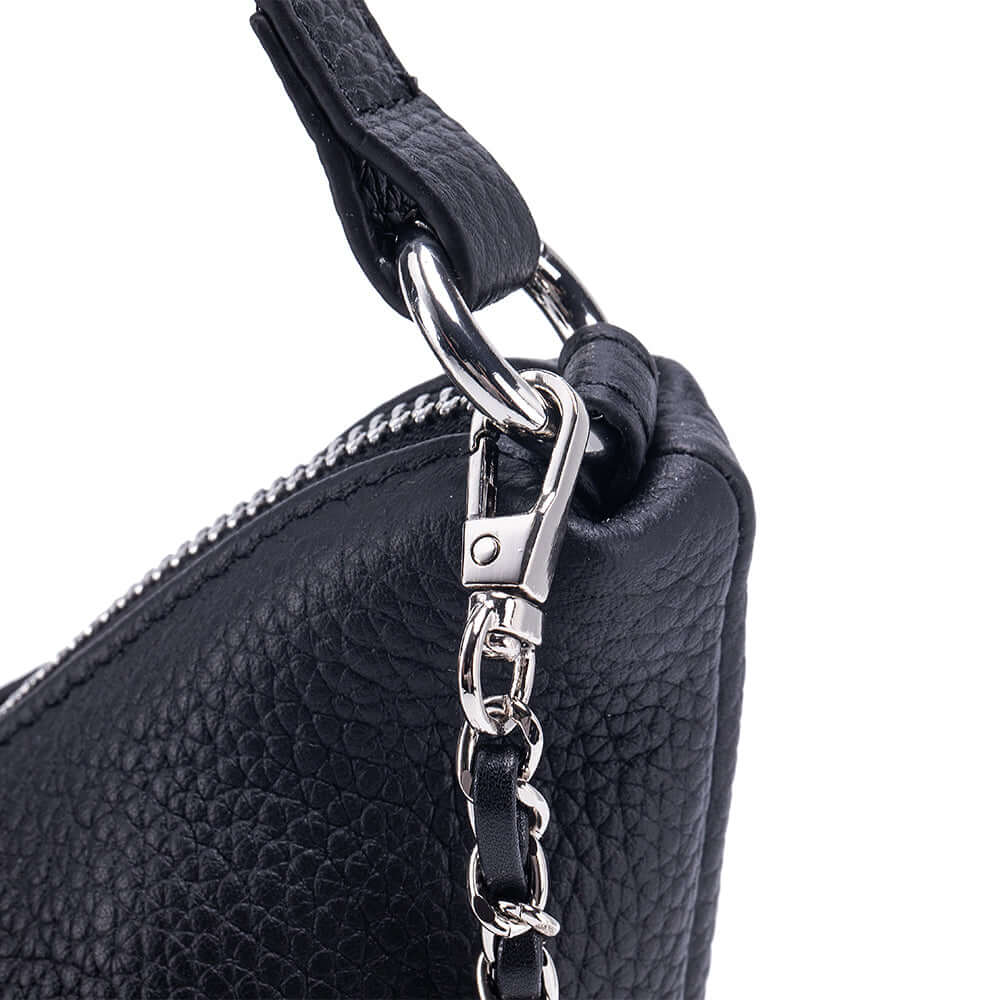 Close-up of a black leather handbag with a silver chain strap