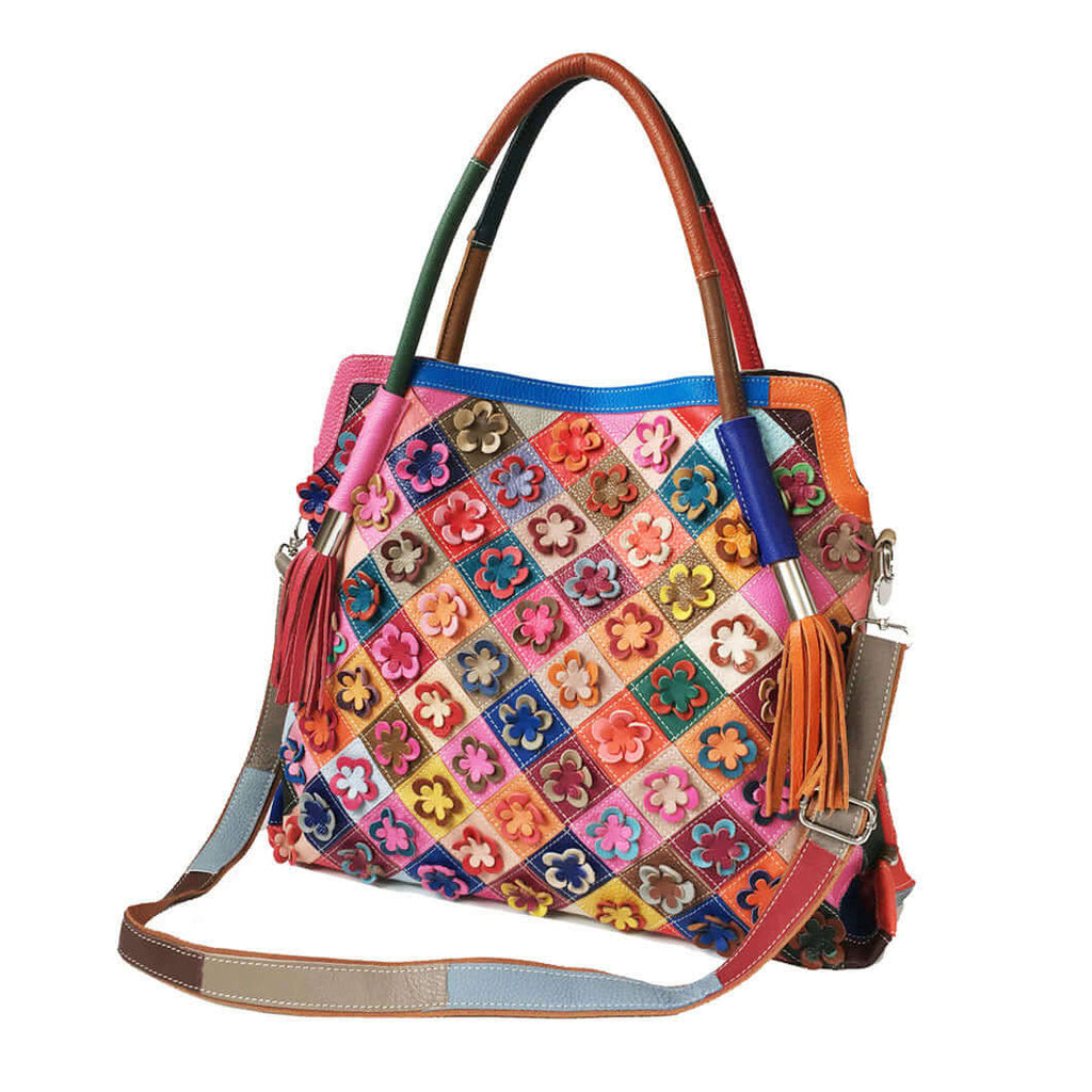 Woman wearing leather tote bag as crossbody with floral design.