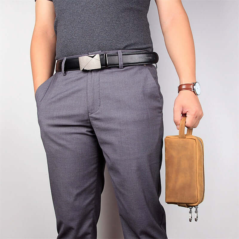 Model holding genuine leather toiletry bag in hand
