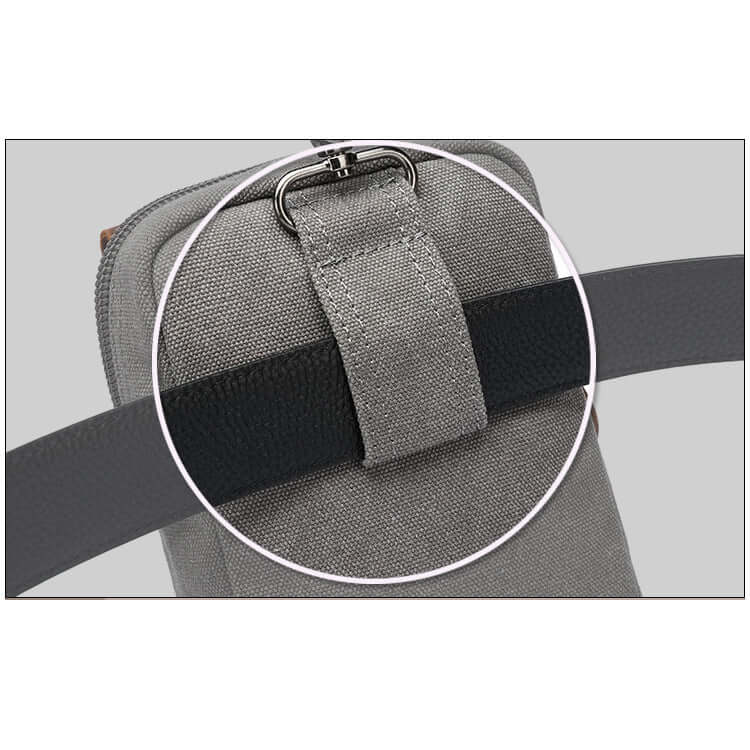Close-up of a grey bag with a black strap and metal buckle