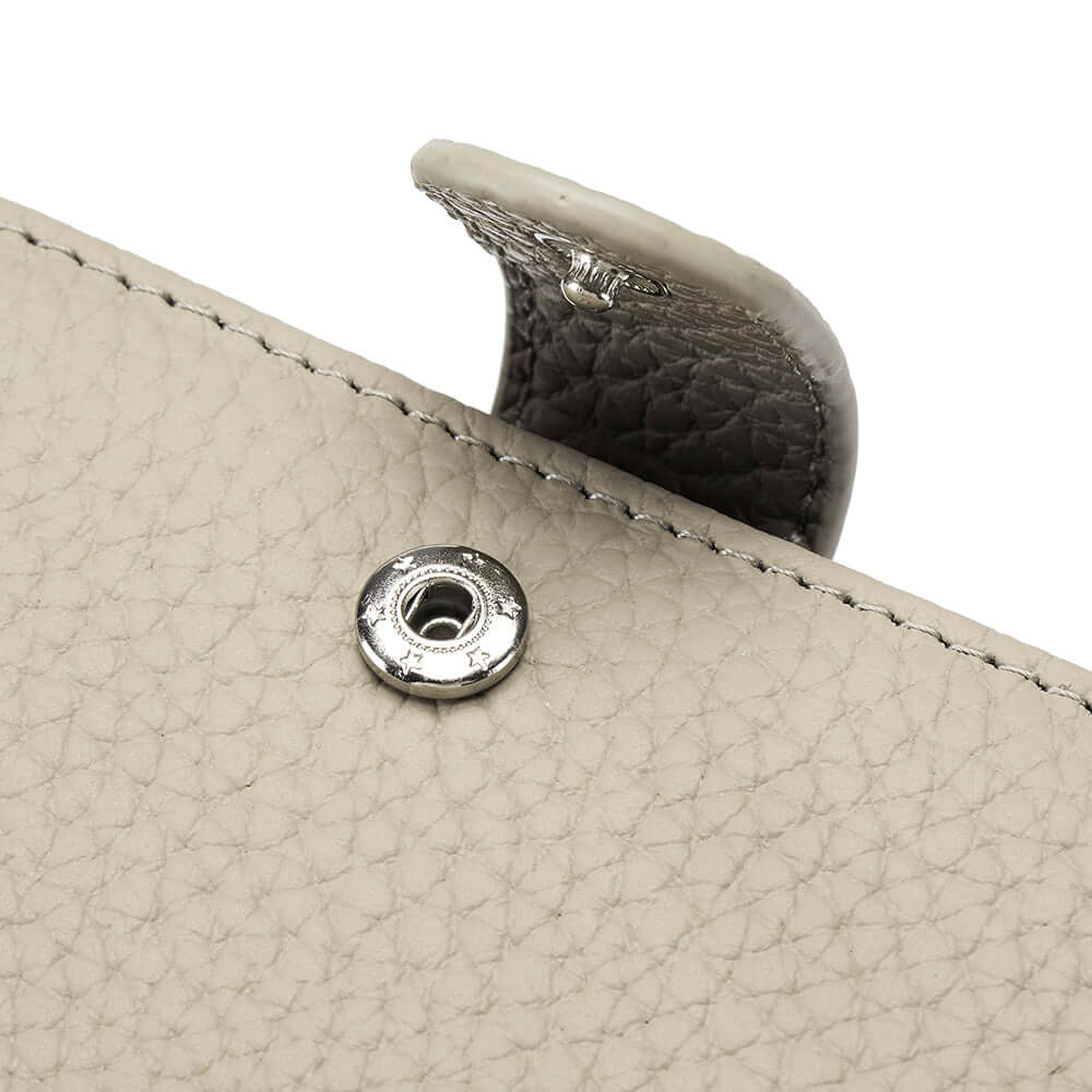Close-up of a grey leather passport wallet with a silver clasp.