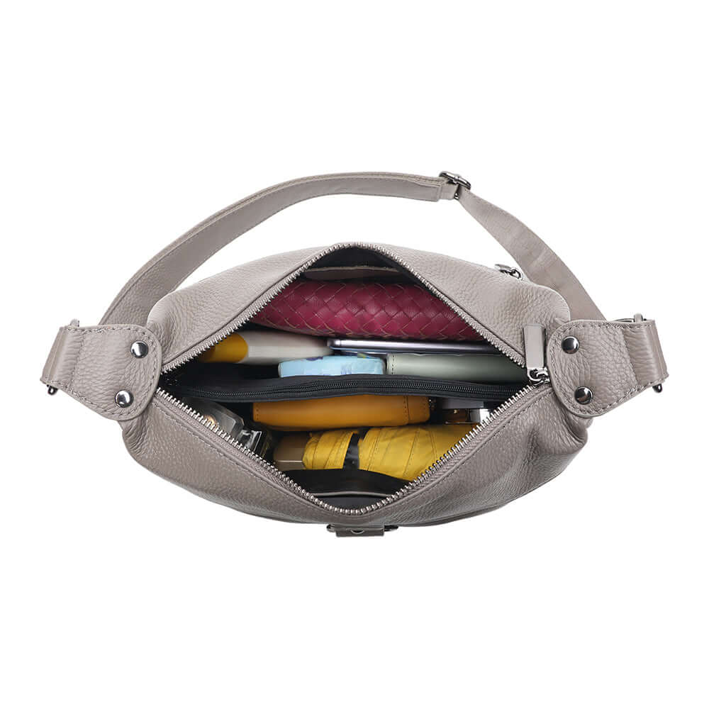 Grey leather shoulder bag shown with daily essentials inside
