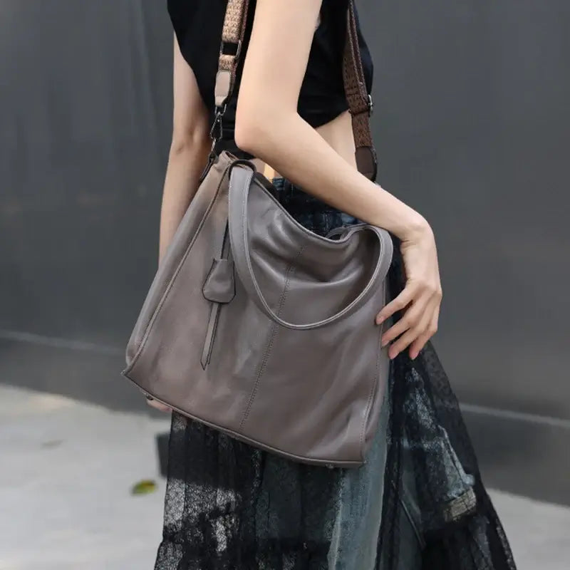 Model walking with grey tote bag in urban street setting