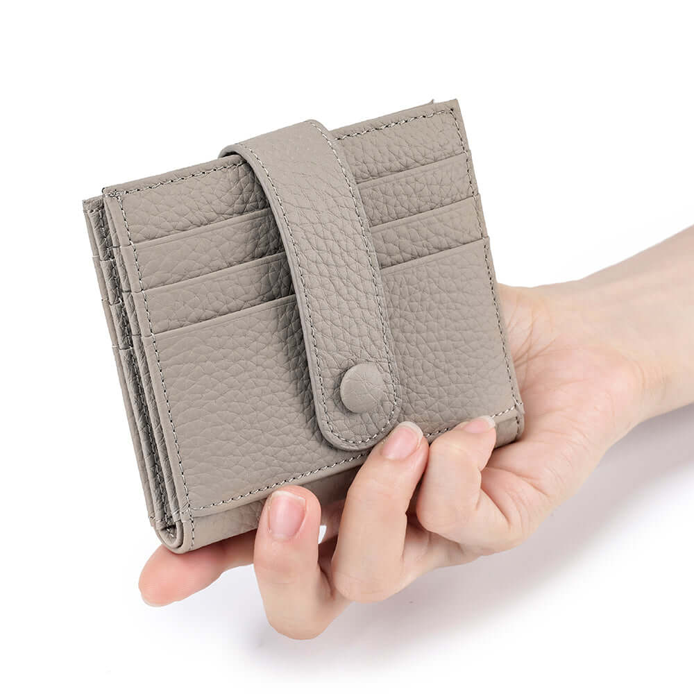 Hand holding a grey leather wallet