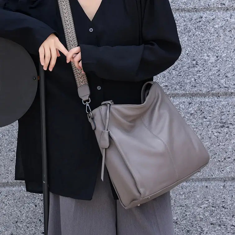 Crossbody styling with adjustable woven strap on grey tote