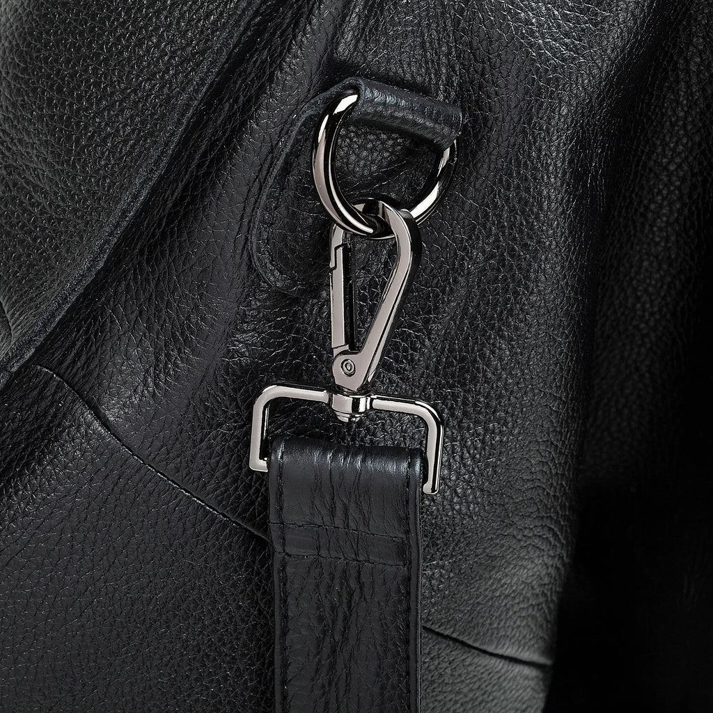 Close-up of a black leather bag with a silver clasp and strap.
