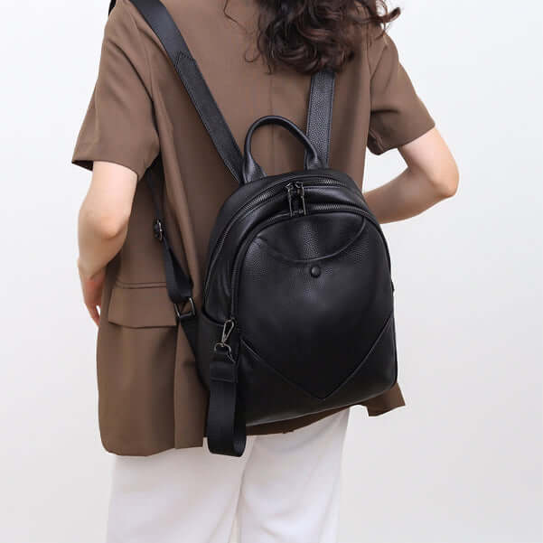 Model carrying black leather backpack on back