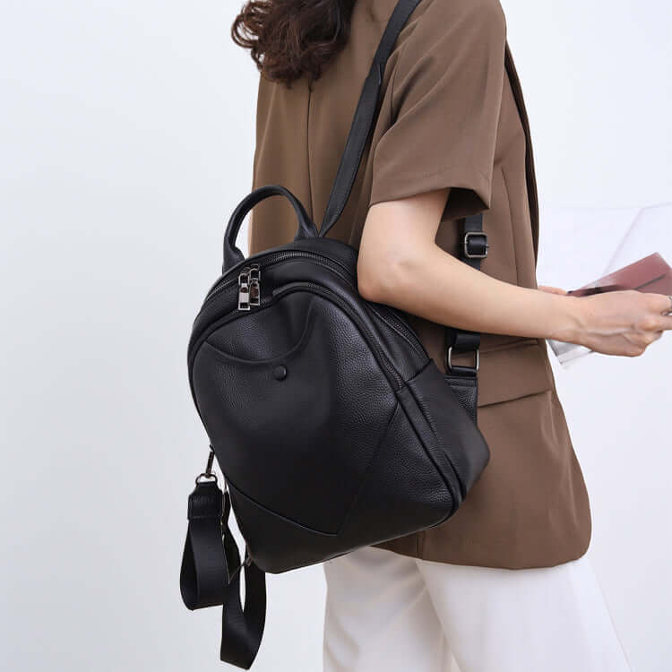 Side look of model wearing leather backpack