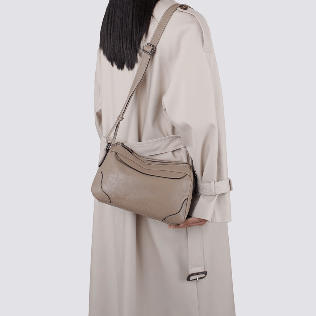 Model wearing leather crossbody bag on shoulder