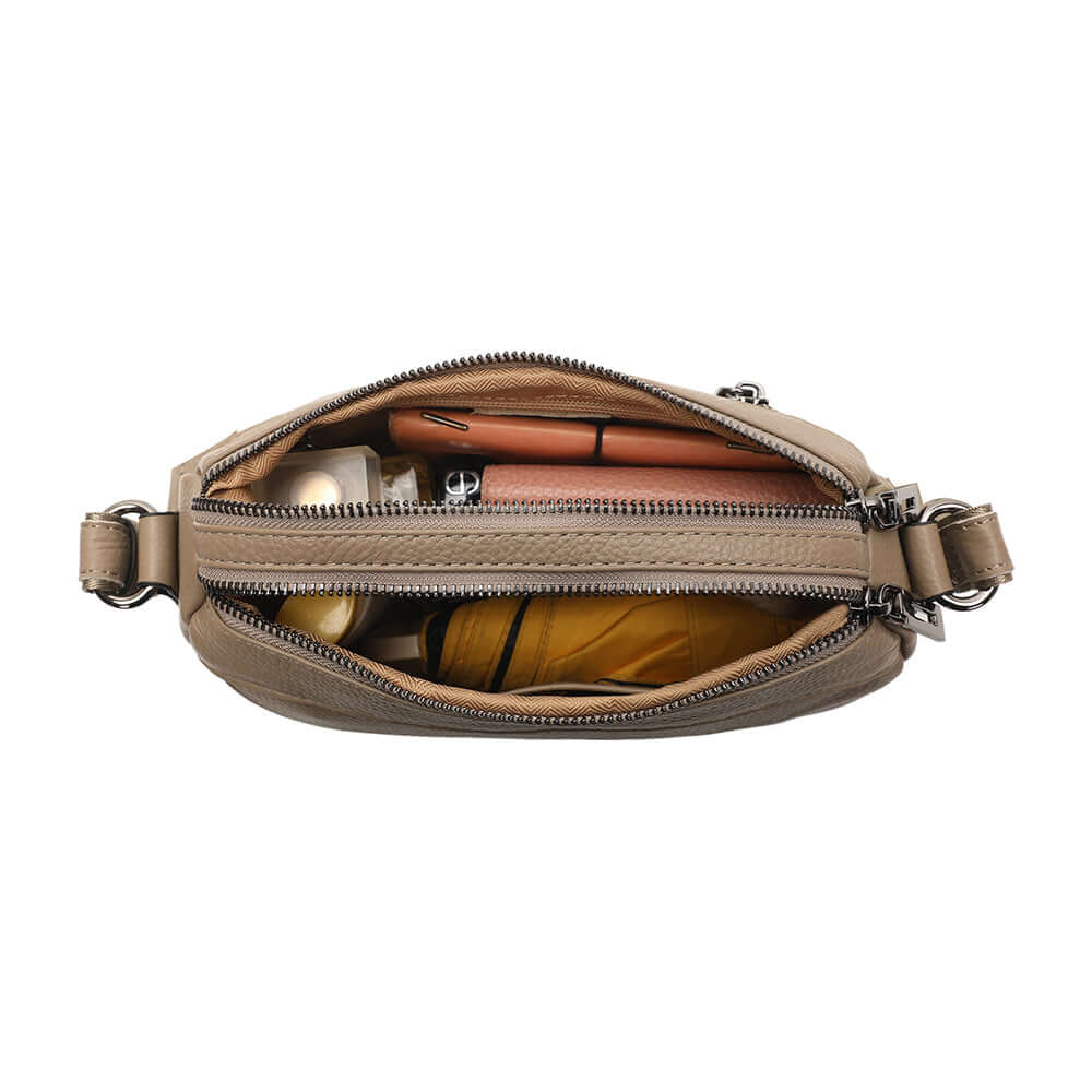 Leather crossbody bag shown with phone wallet cosmetics and keys