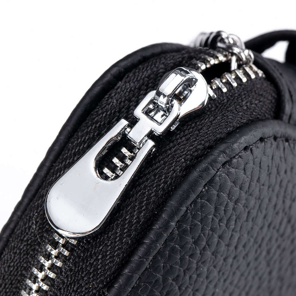 Close-up of metal zip and fine leather texture on earbud case.