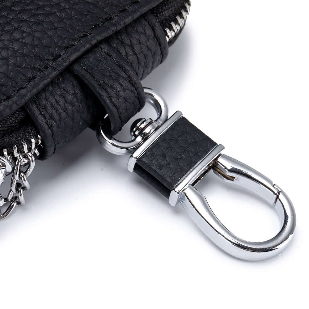 Black leather earbud case with silver keychain on a white background.
