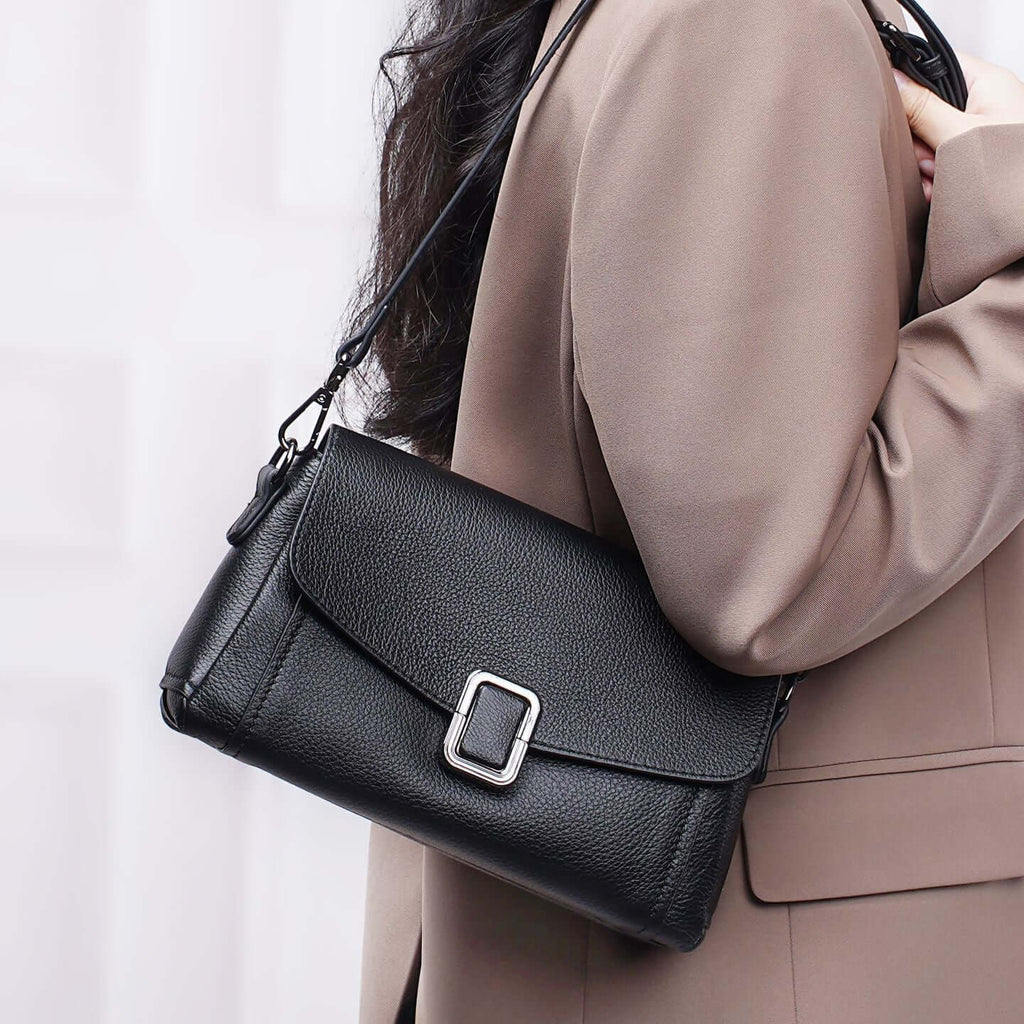 Woman carrying black leather flap crossbody bag