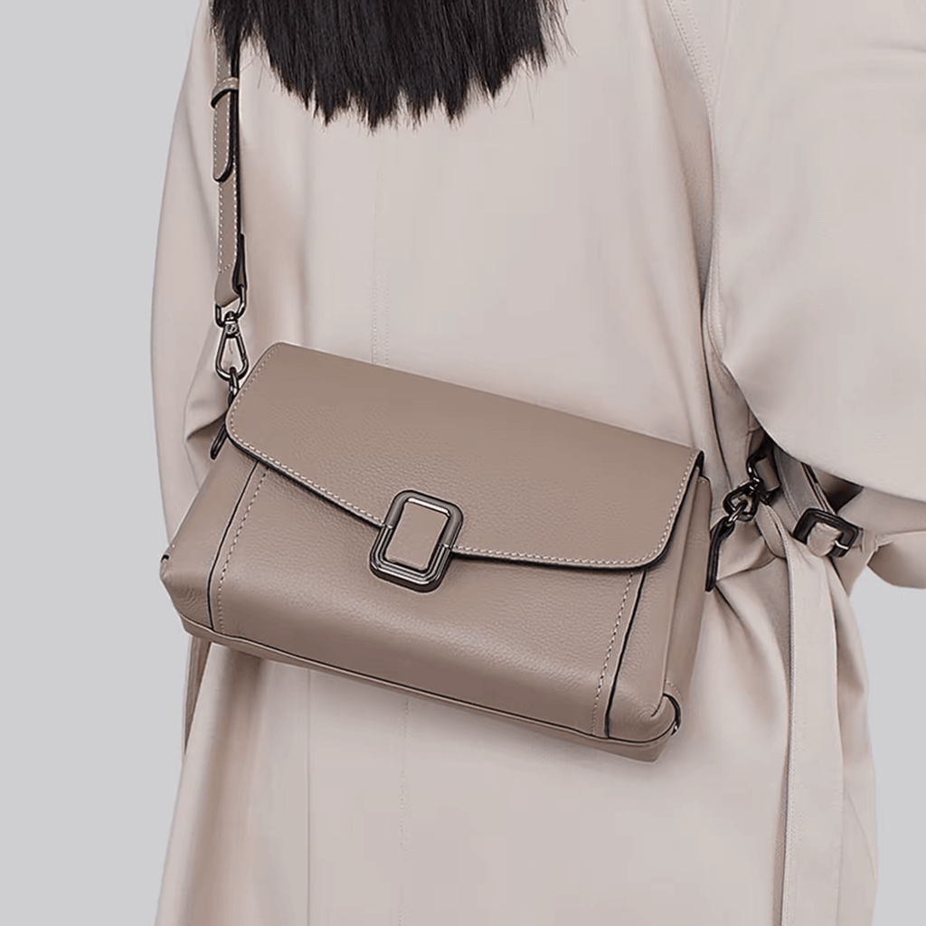 Woman carrying taupe leather flap crossbody bag