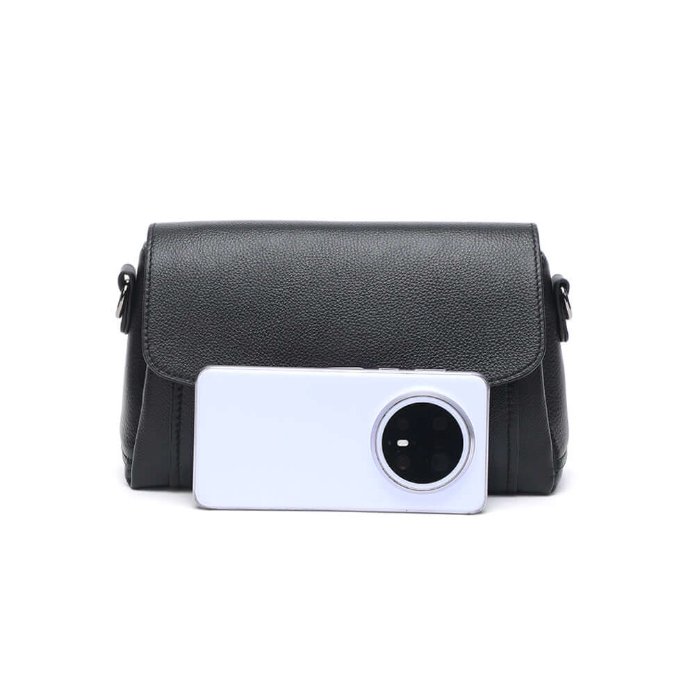 size comparison of leather flap shoulder bag beside phone