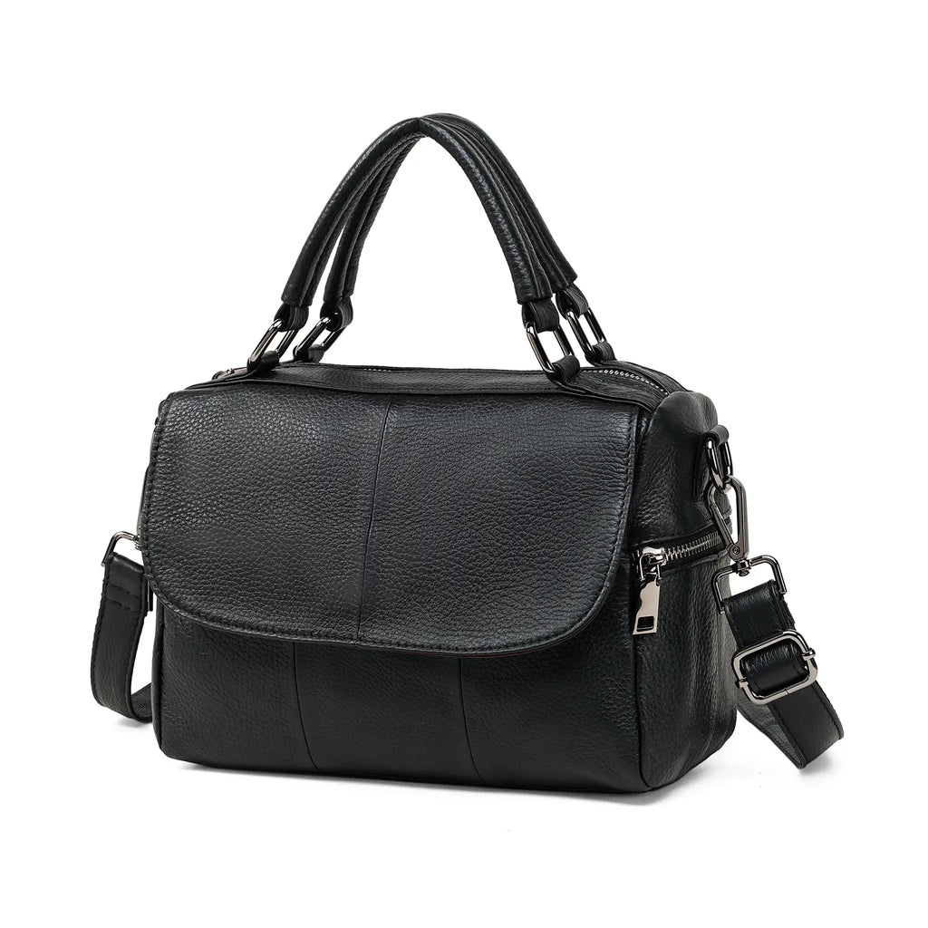 Front view of black genuine leather handbag with flap and handles.