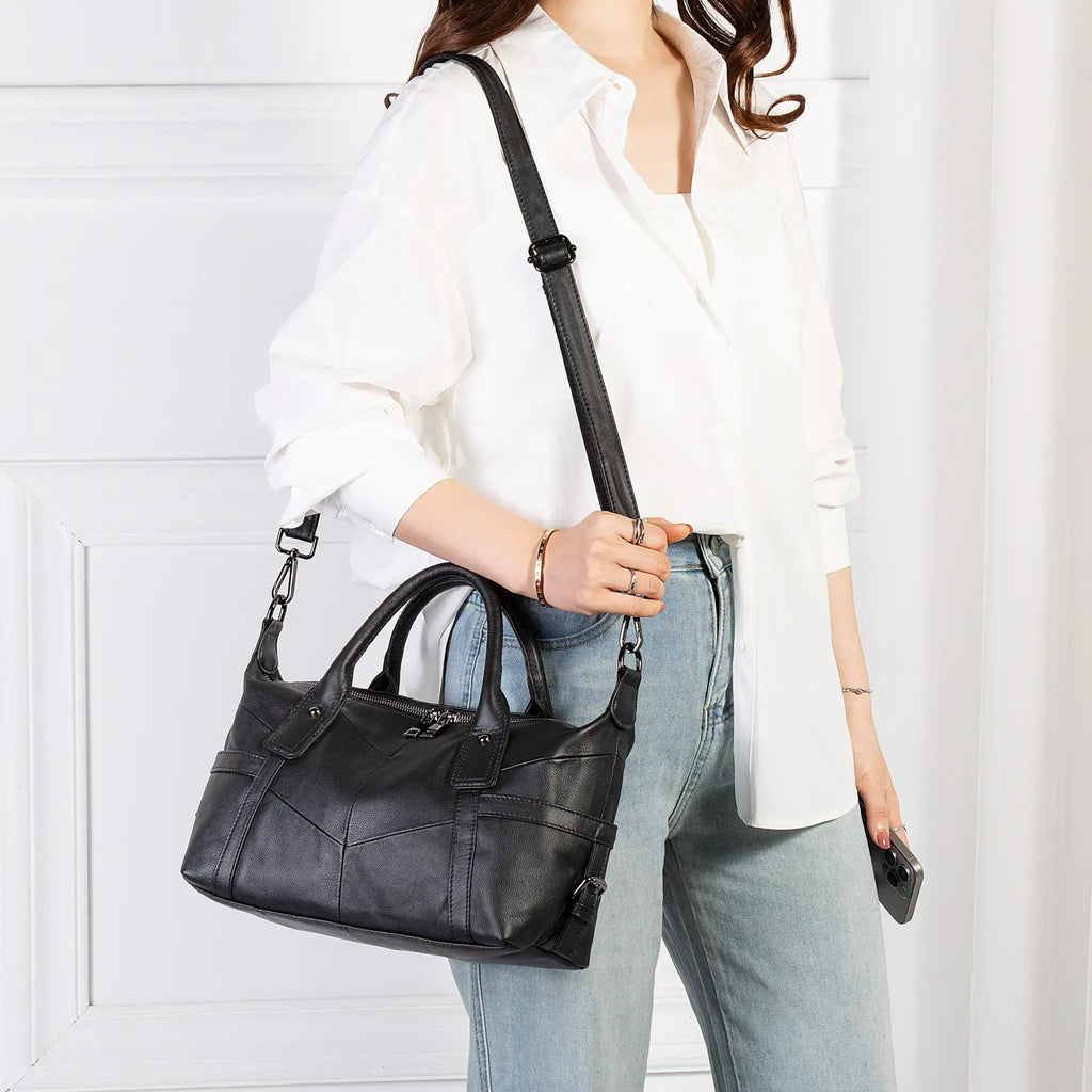 Model carrying black leather handbag over shoulder