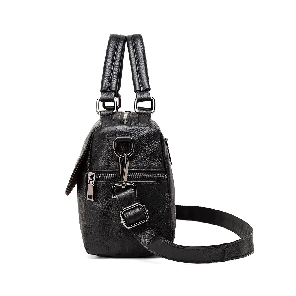 Side angle of black leather handbag showing side zipper pocket and soft leather texture.