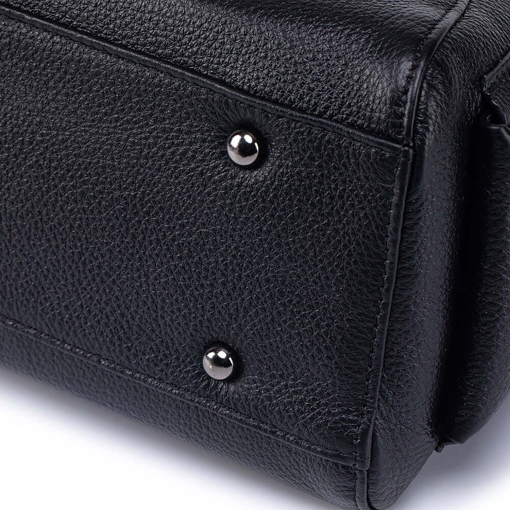 Woman wearing black leather shoulder bag crossbody.