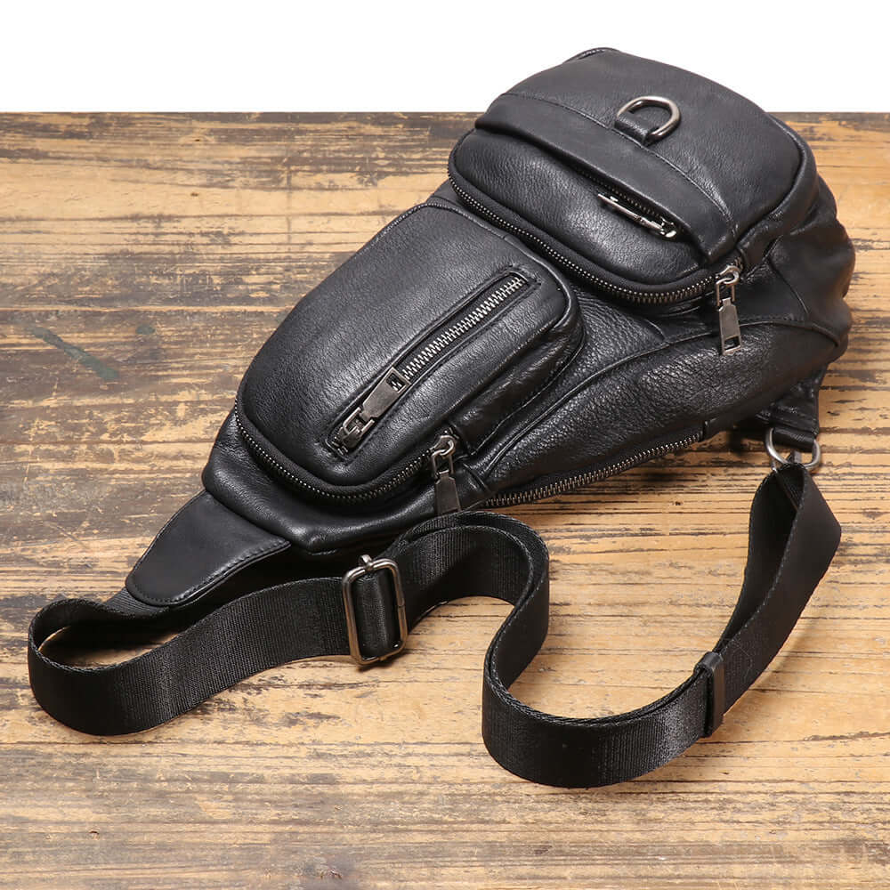 flat lay of black leather sling bag with strap